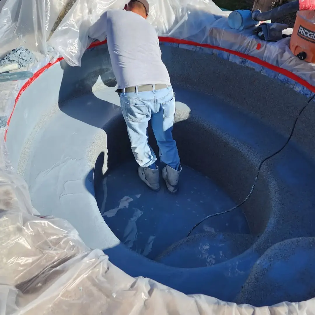 Un técnico aplicando acabado de piedra en un jacuzzi