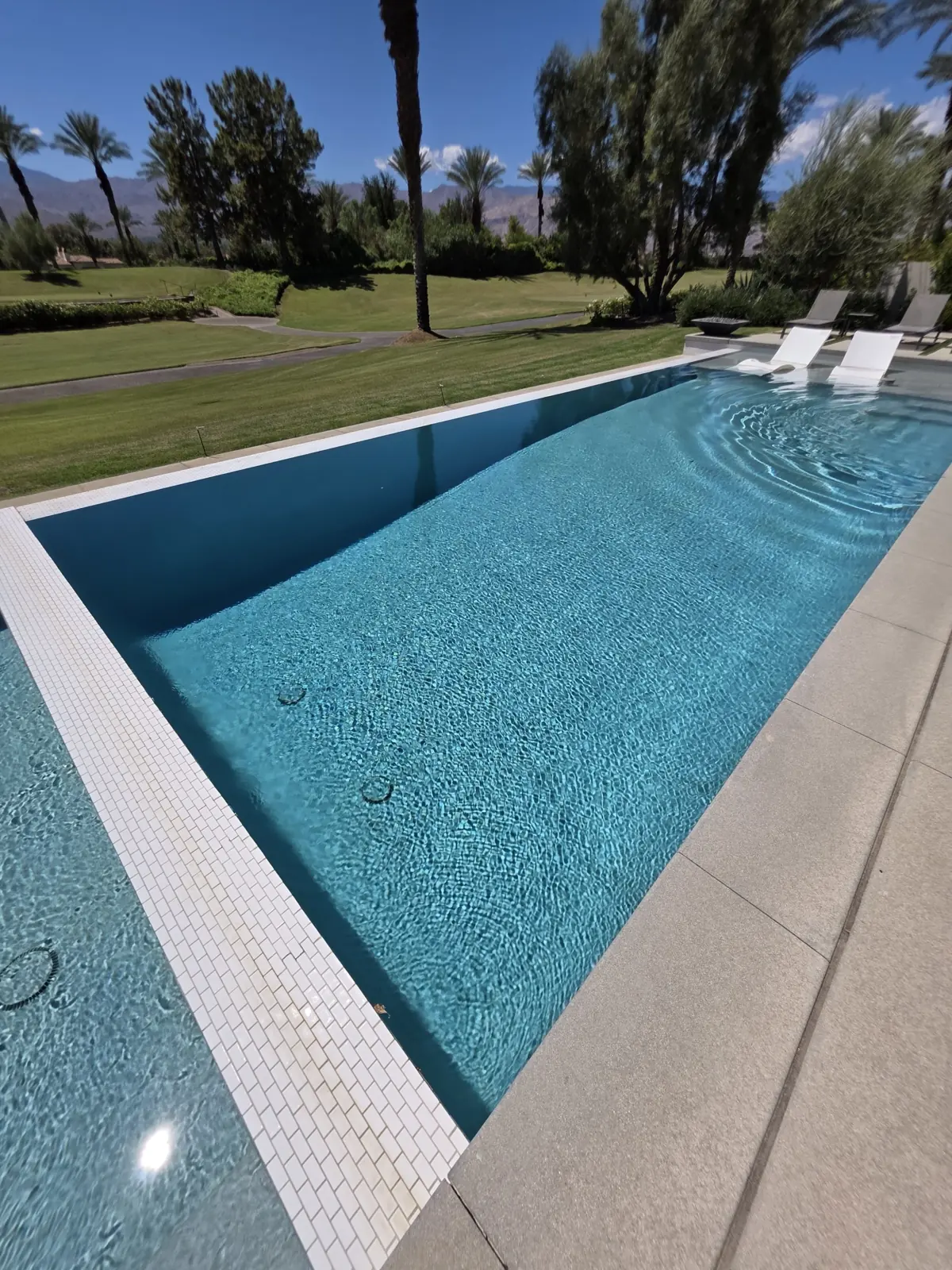 Long pool with a tile border and loungers